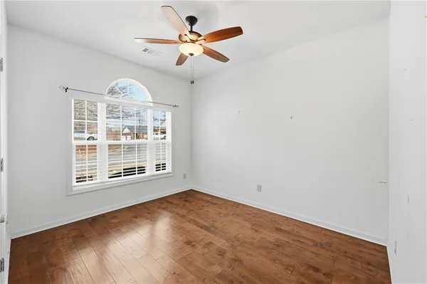 a view of an empty room with wooden floor
