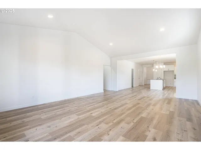 a view of empty room with wooden floor and fireplace