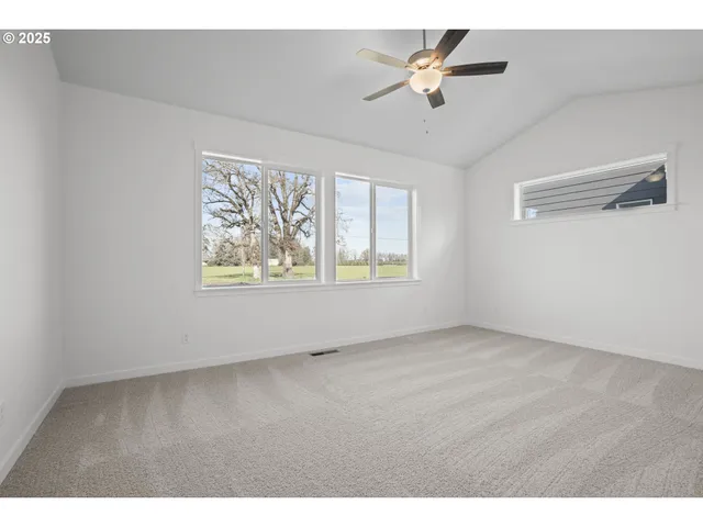 a view of an empty room and chandelier fan