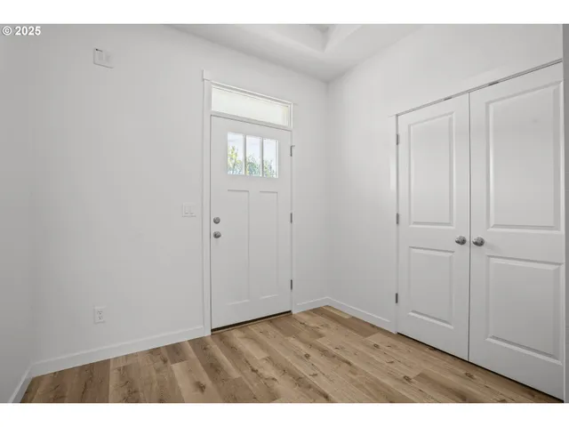 a view of an empty room with closet and a window