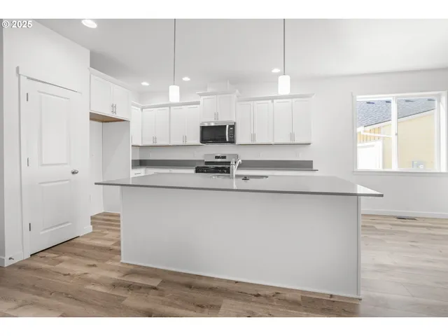 a kitchen with kitchen island white cabinets and stainless steel appliances