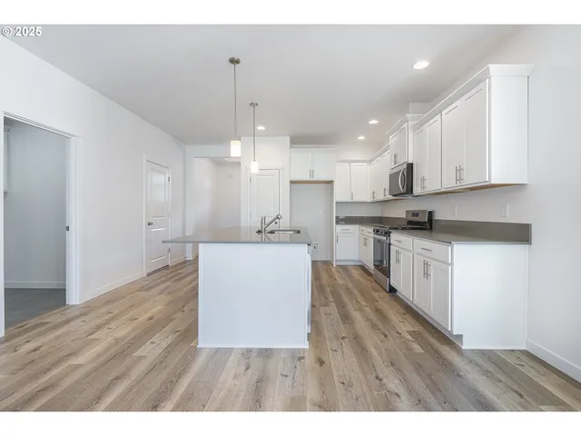 a kitchen with kitchen island white cabinets and stainless steel appliances