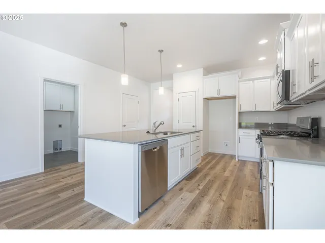 a kitchen with kitchen island a sink stainless steel appliances and cabinets