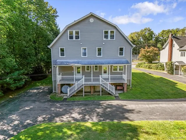 a front view of a house with a yard and potted plants