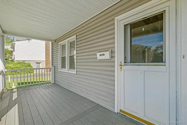 a view of a porch with a door and wooden floor