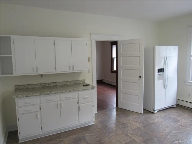a kitchen with granite countertop white cabinets and sink