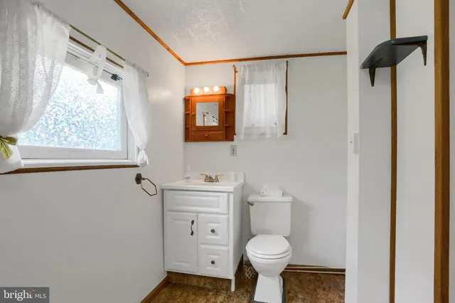 a bathroom with a granite countertop toilet sink and mirror