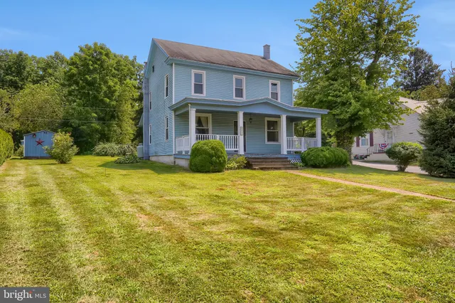 a front view of house with yard and trees around