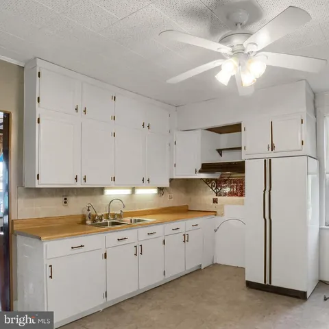 a kitchen with stainless steel appliances granite countertop a refrigerator sink and white cabinets