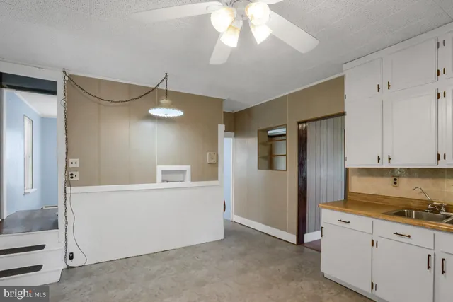 a view of a kitchen with an empty space and a ceiling fan