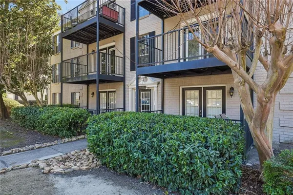 a view of a house with a yard and potted plants