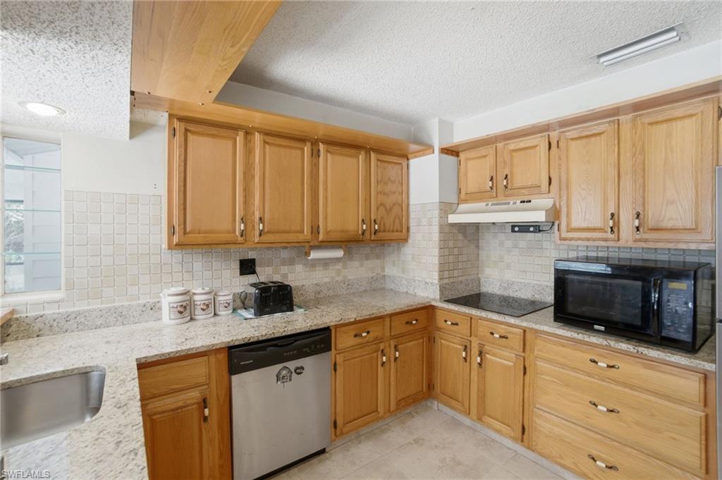 3670 27th Avenue Southwest Naples, FL 34117 - Photo 15 of 38 a kitchen with granite countertop white cabinets stainless steel appliances a sink and a window