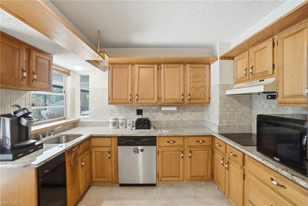 3670 27th Avenue Southwest Naples, FL 34117 - Photo 16 of 38 a kitchen with stainless steel appliances granite countertop a sink stove and cabinets