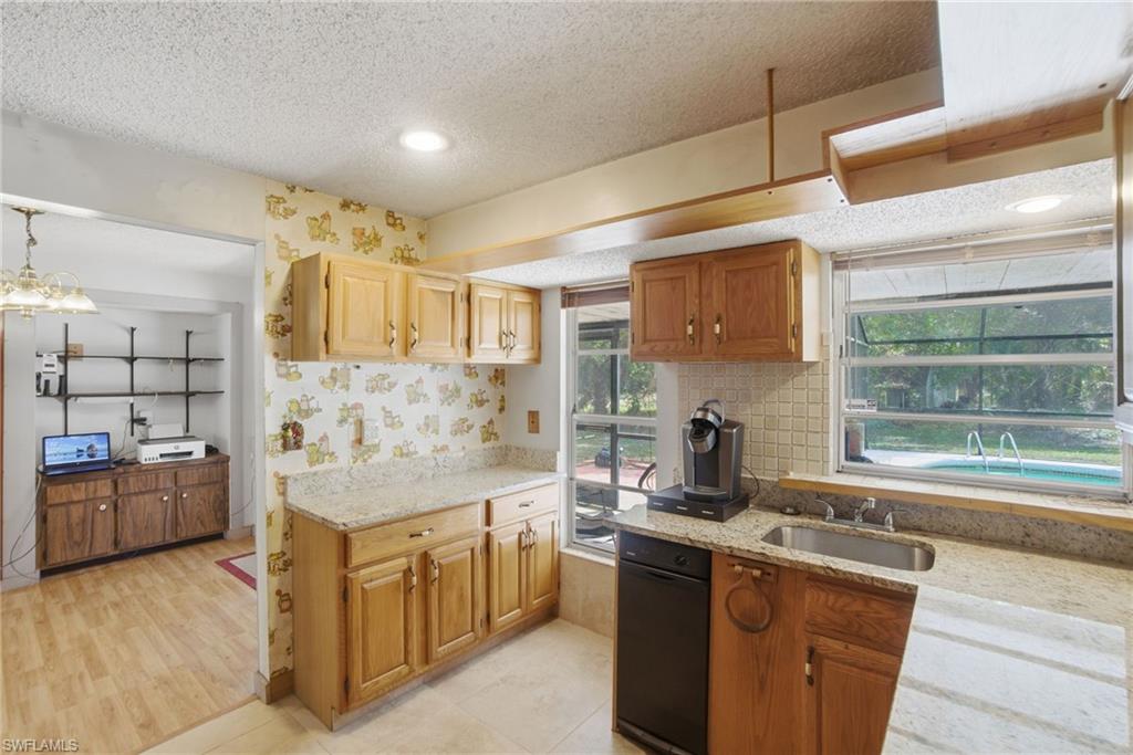 3670 27th Avenue Southwest Naples, FL 34117 - Photo 18 of 38 a kitchen with stainless steel appliances granite countertop a sink stove and refrigerator