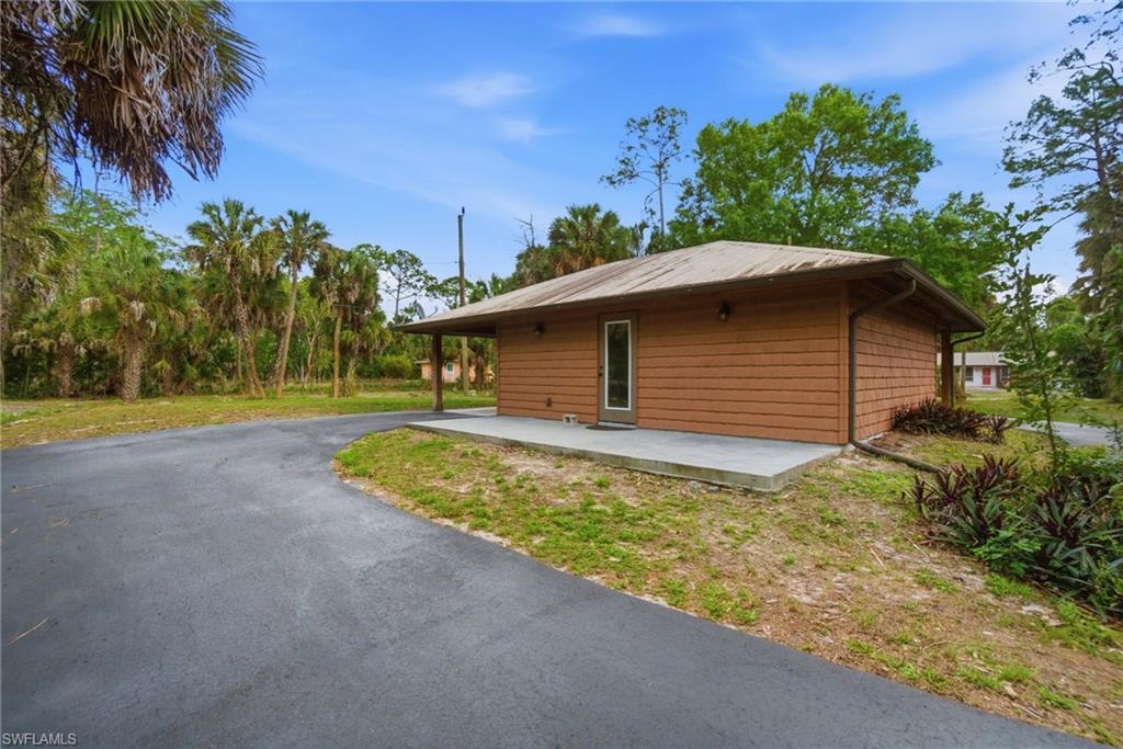 3670 27th Avenue Southwest Naples, FL 34117 - Photo 30 of 38 a backyard of a house with large trees and plants
