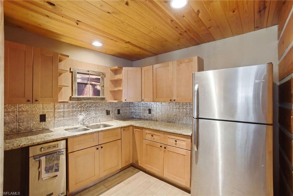 3670 27th Avenue Southwest Naples, FL 34117 - Photo 32 of 38 a kitchen with stainless steel appliances granite countertop a refrigerator sink and cabinets