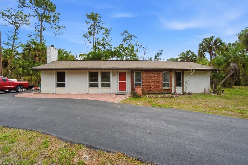 3670 27th Avenue Southwest Naples, FL 34117 - Photo 5 of 38 a front view of a house with a yard and garage