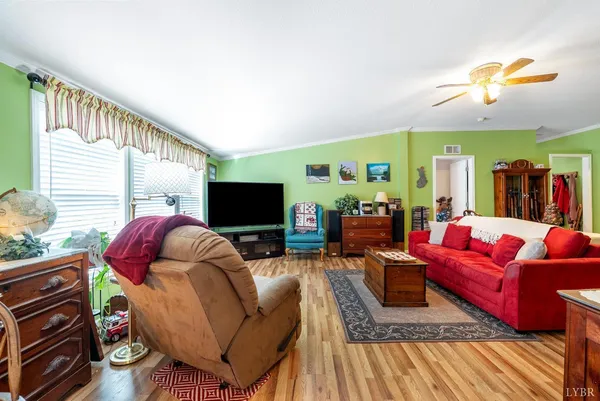 a living room with furniture a flat screen tv and a large window