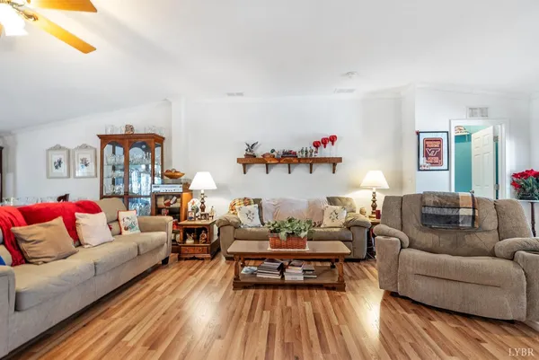 a living room with furniture kitchen view and a wooden floor