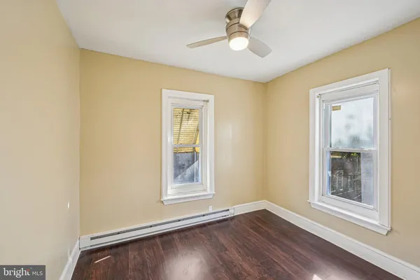 a view of room with window ceiling fan and hardwood floor