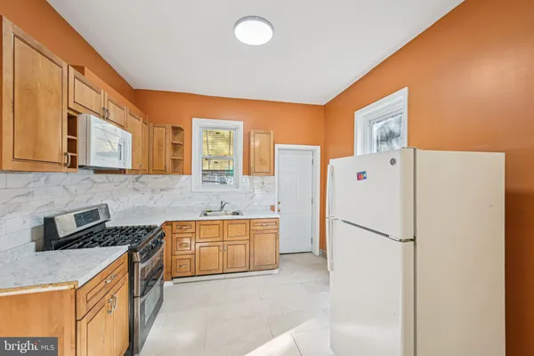 a kitchen with stainless steel appliances granite countertop a refrigerator a stove and a sink