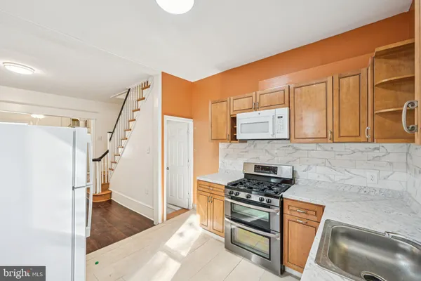 a kitchen with stainless steel appliances granite countertop a stove a sink and a refrigerator