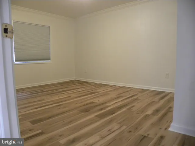 a view of a room with wooden floor and white walls