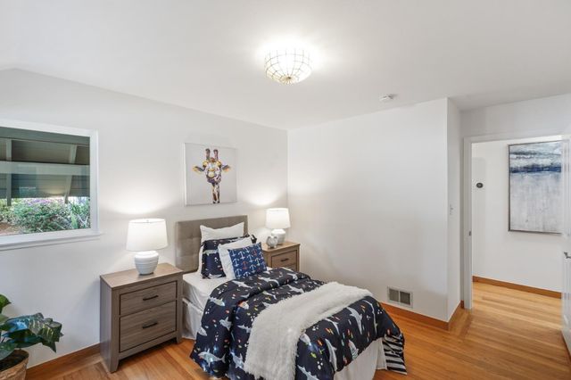 a bedroom with a bed and a painting on the wall