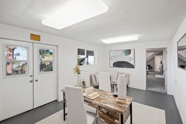 a balcony with wooden floor table and chairs