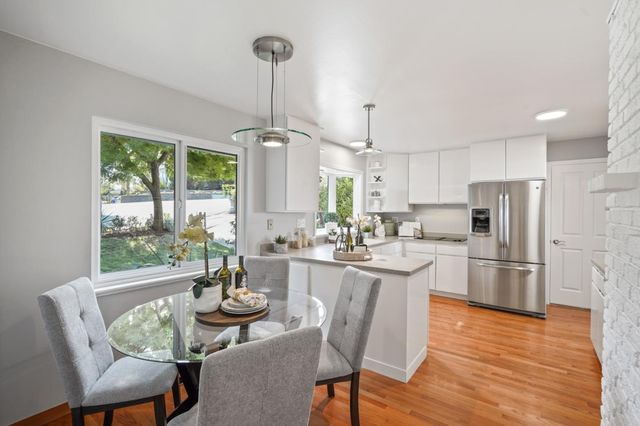 a kitchen with refrigerator cabinets dining table and chairs