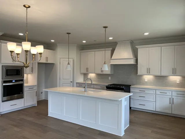 a kitchen with kitchen island granite countertop a sink a counter space stainless steel appliances and cabinets