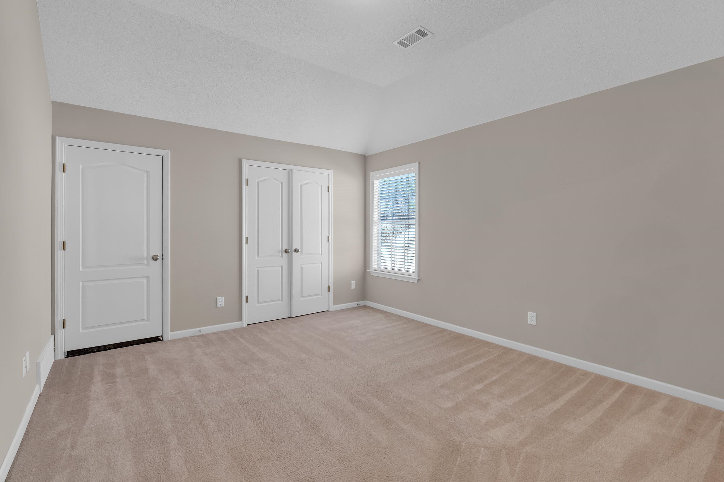 1229 North Sanga Road Memphis, TN 38016 - Photo 15 of 32 Unfurnished bedroom with light colored carpet, lofted ceiling, and a closet