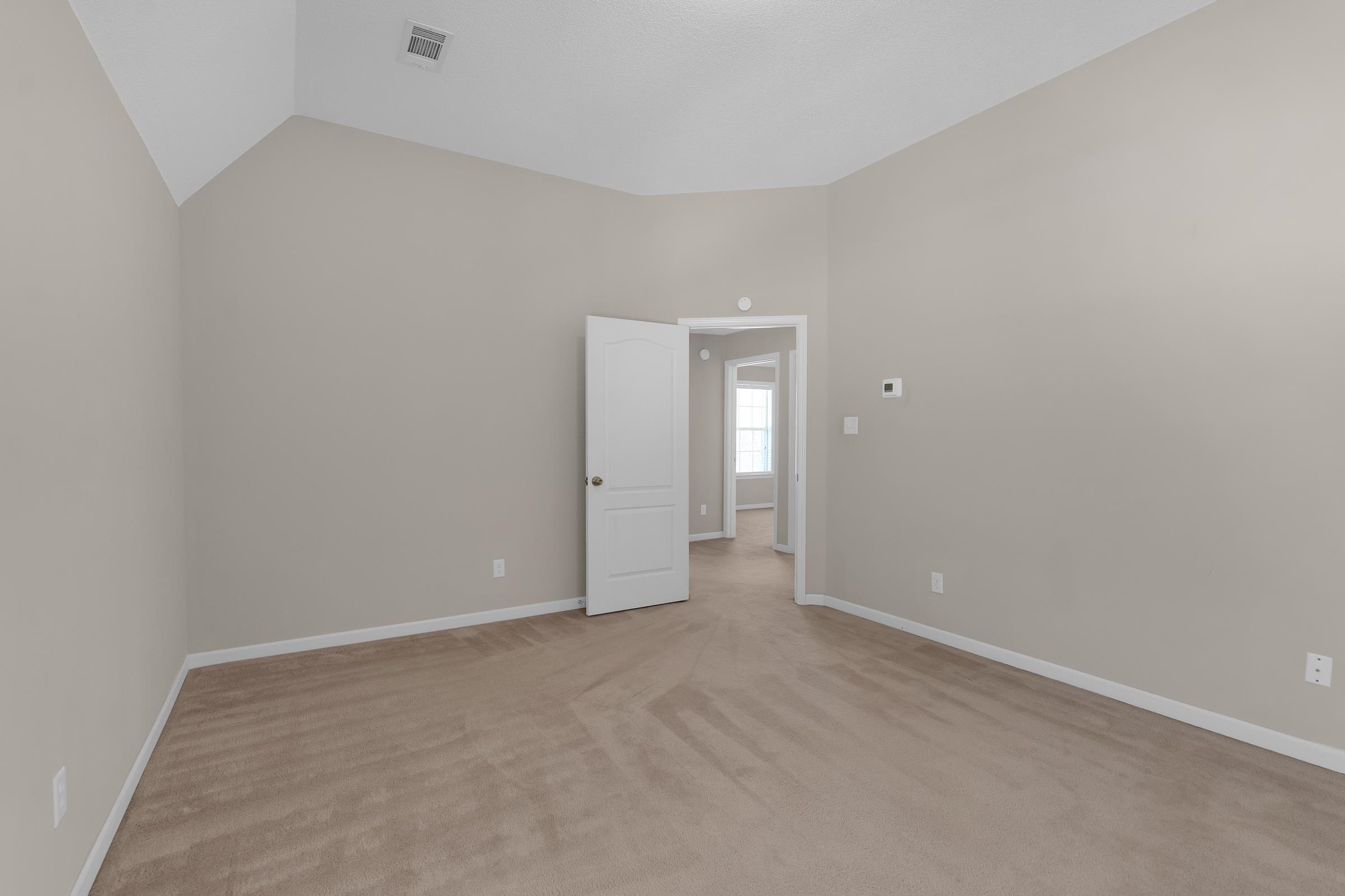 1229 North Sanga Road Memphis, TN 38016 - Photo 16 of 32 Empty room with light carpet and lofted ceiling