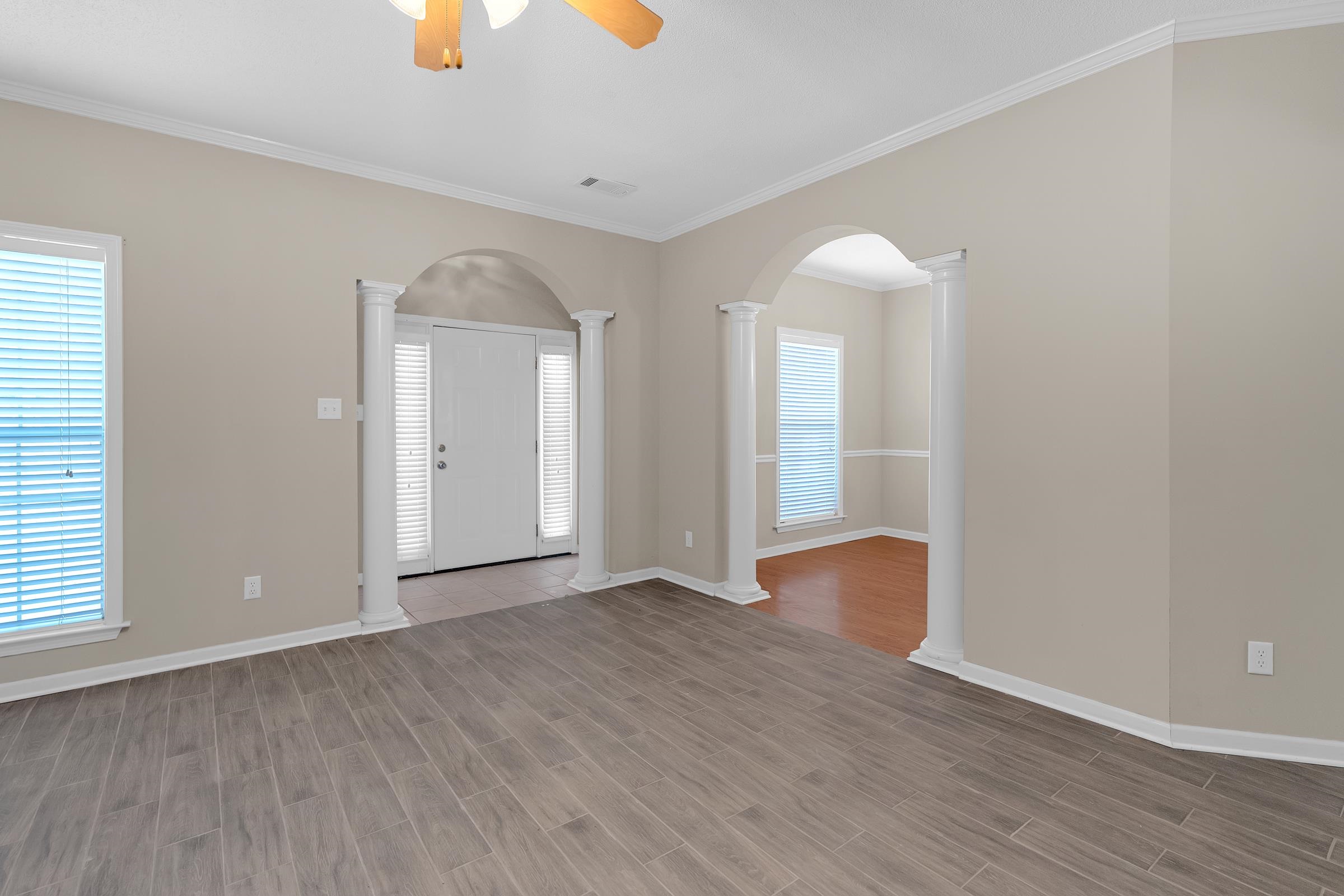 1229 North Sanga Road Memphis, TN 38016 - Photo 22 of 32 Foyer entrance featuring wood tiled floors, crown molding, a ceiling fan, arched walkways, and ornate columns