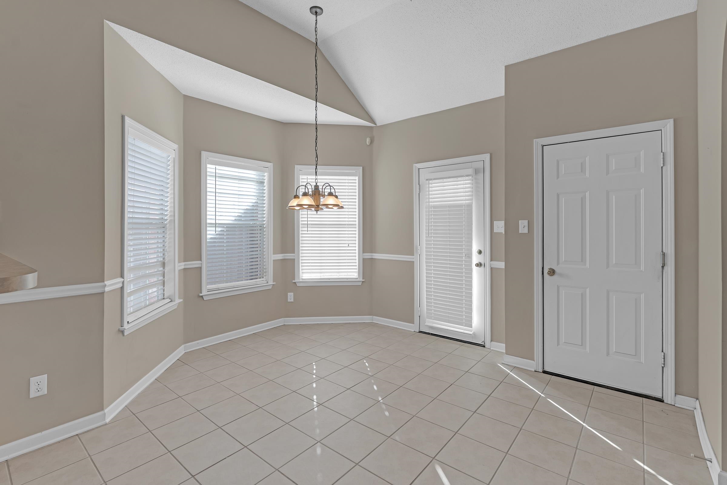 1229 North Sanga Road Memphis, TN 38016 - Photo 23 of 32 Foyer entrance with light tile patterned floors, vaulted ceiling, and a chandelier