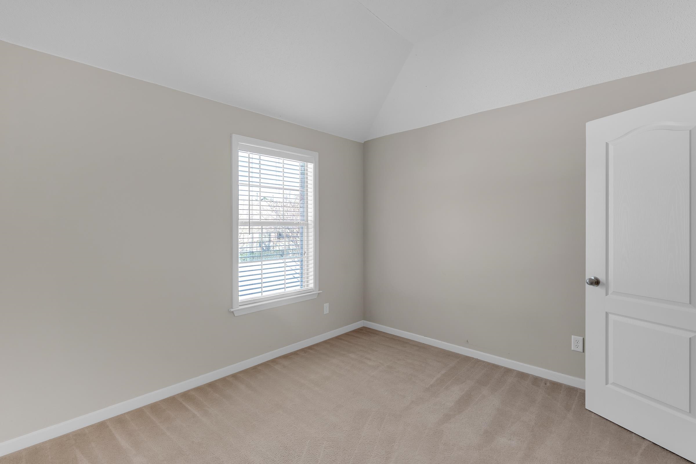 1229 North Sanga Road Memphis, TN 38016 - Photo 24 of 32 Spare room featuring light carpet and vaulted ceiling