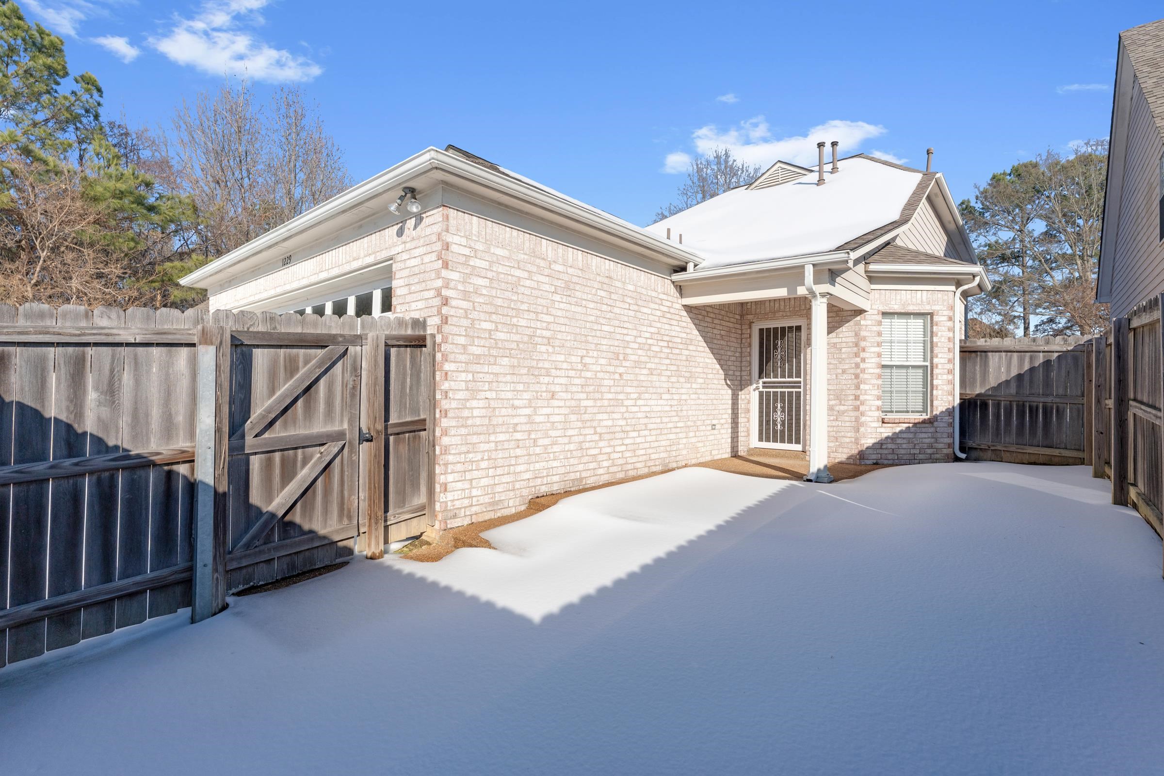 1229 North Sanga Road Memphis, TN 38016 - Photo 26 of 32 View of side of home featuring a gate, a fenced backyard, brick siding, and a patio area
