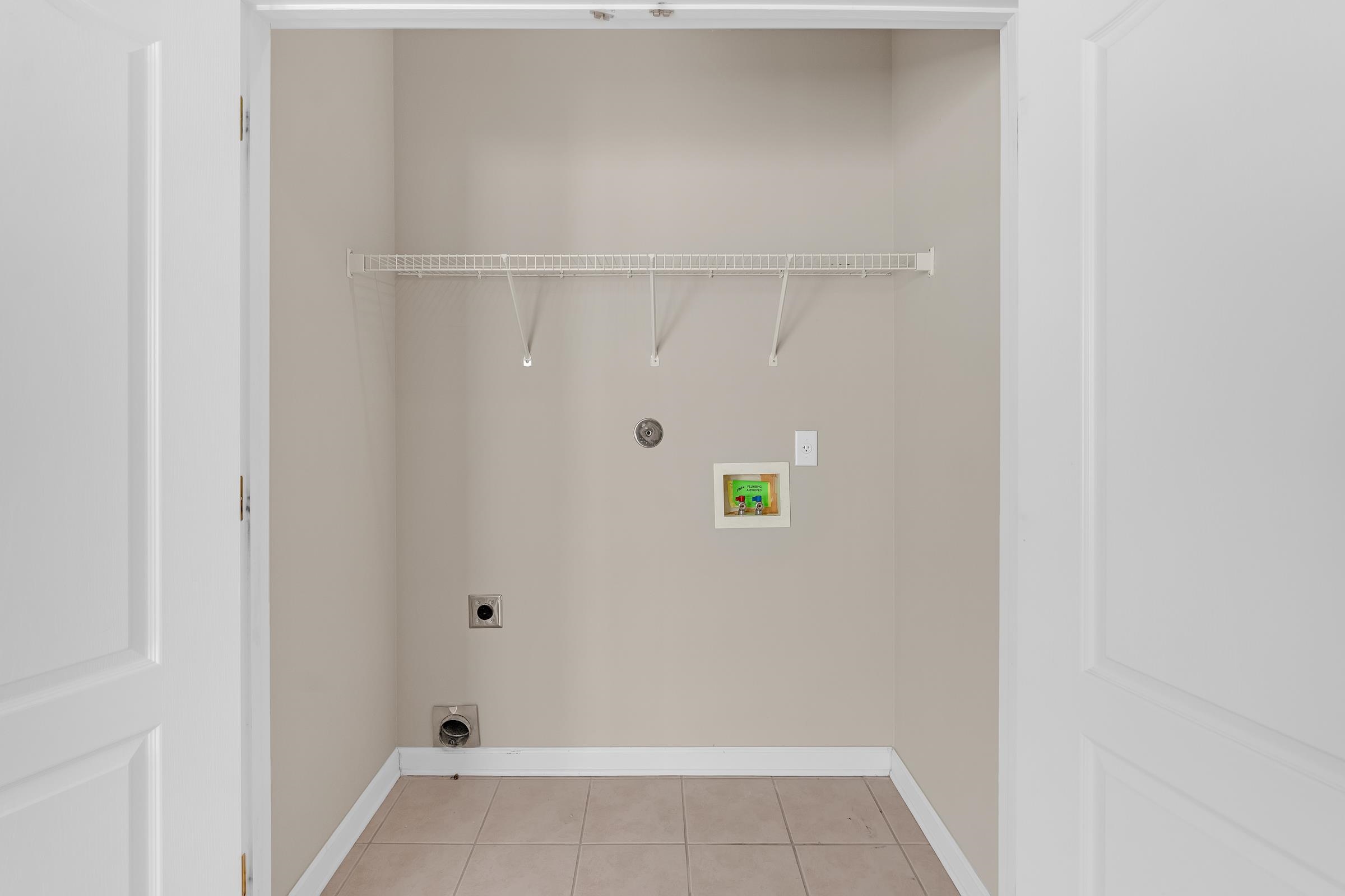 1229 North Sanga Road Memphis, TN 38016 - Photo 9 of 32 Laundry area with electric dryer hookup, hookup for a washing machine, and light tile patterned flooring