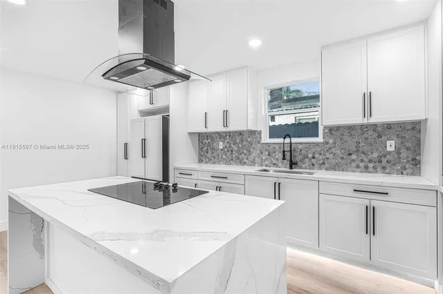 a kitchen with stainless steel appliances a sink dishwasher a stove white countertops with wooden floor