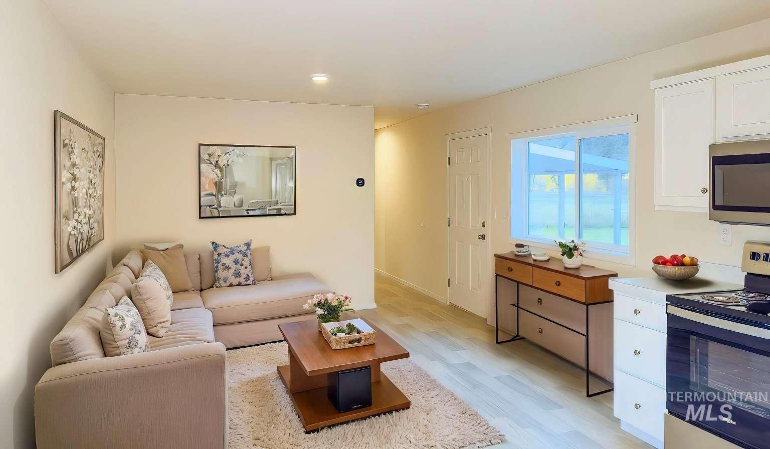 10 Kamloop Lane Orofino, ID 83544 - Photo 2 of 17 Bright open-concept living area featuring light wood-finish flooring, recessed lighting, a white painted door, and a large window