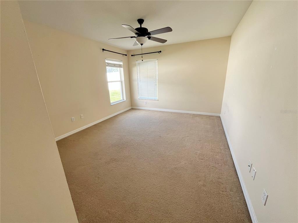 4420 Southwest 100th Street Ocala, FL 34476 - Photo 13 of 22 an empty room with a ceiling fan and a window