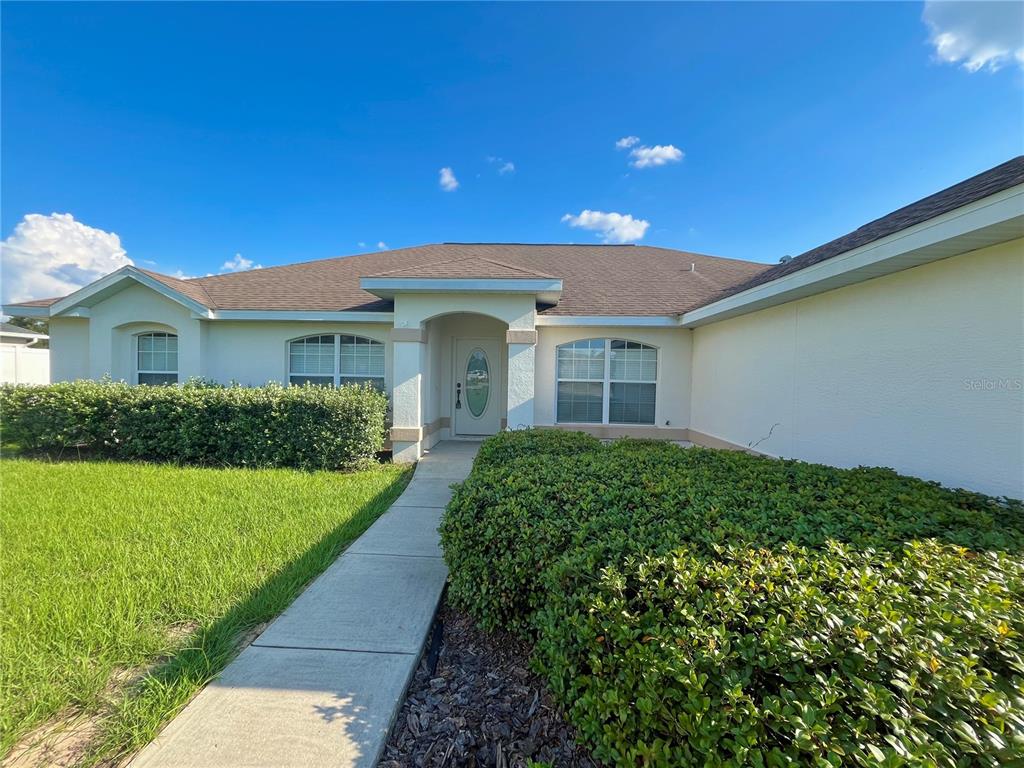 4420 Southwest 100th Street Ocala, FL 34476 - Photo 2 of 22 a front view of a house with a yard