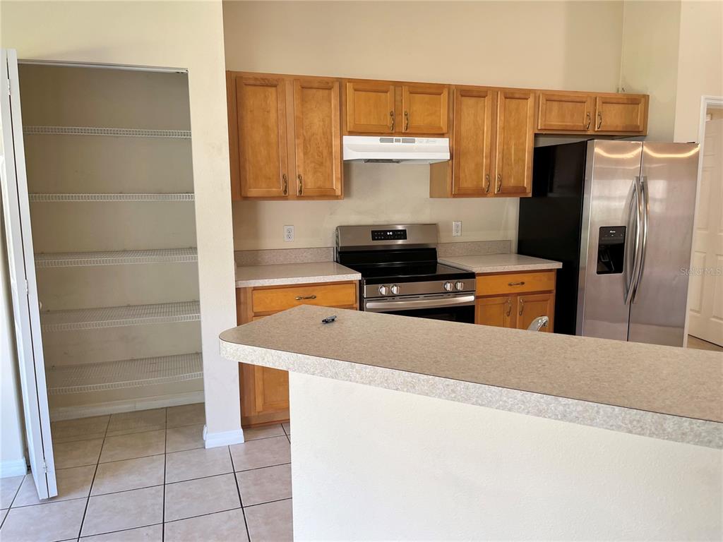 4420 Southwest 100th Street Ocala, FL 34476 - Photo 5 of 22 a kitchen with stainless steel appliances a refrigerator and a stove