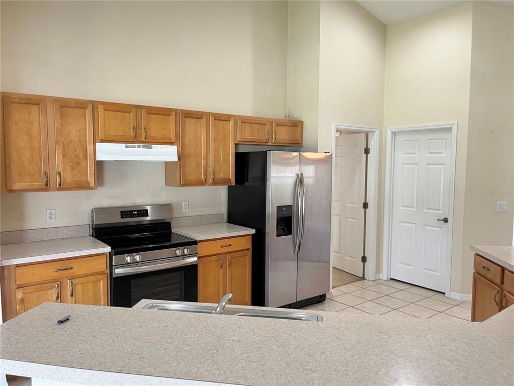 4420 Southwest 100th Street Ocala, FL 34476 - Photo 6 of 22 a kitchen with stainless steel appliances a stove a refrigerator and a sink