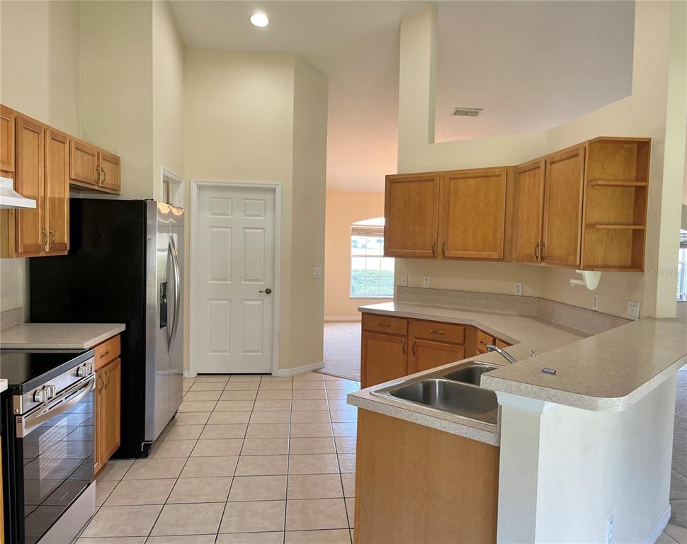 4420 Southwest 100th Street Ocala, FL 34476 - Photo 7 of 22 a kitchen with a stove a refrigerator and cabinets