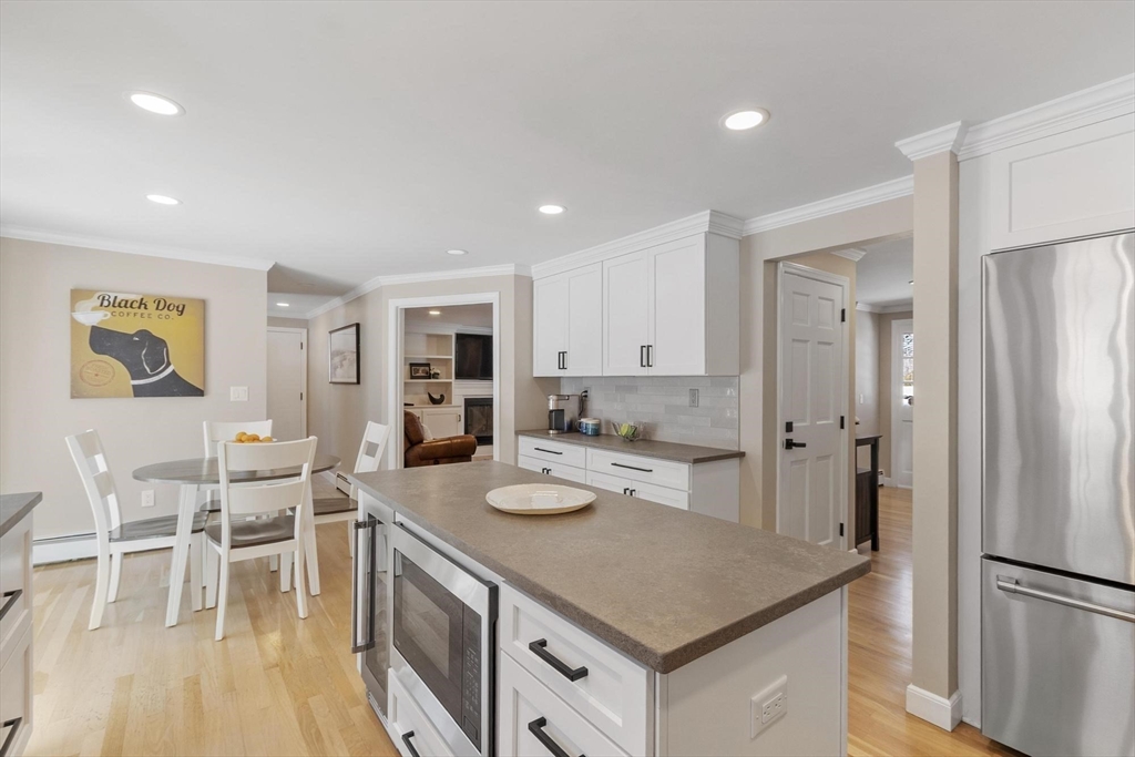 2 Greybirch Road Andover, MA 01810 - Photo 6 of 41 a kitchen with stainless steel appliances granite countertop a refrigerator a stove and a dining table with wooden floor