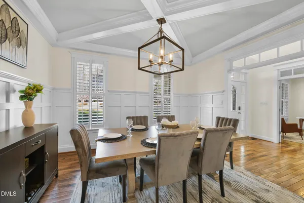 a view of a dining room with furniture a chandelier and wooden floor