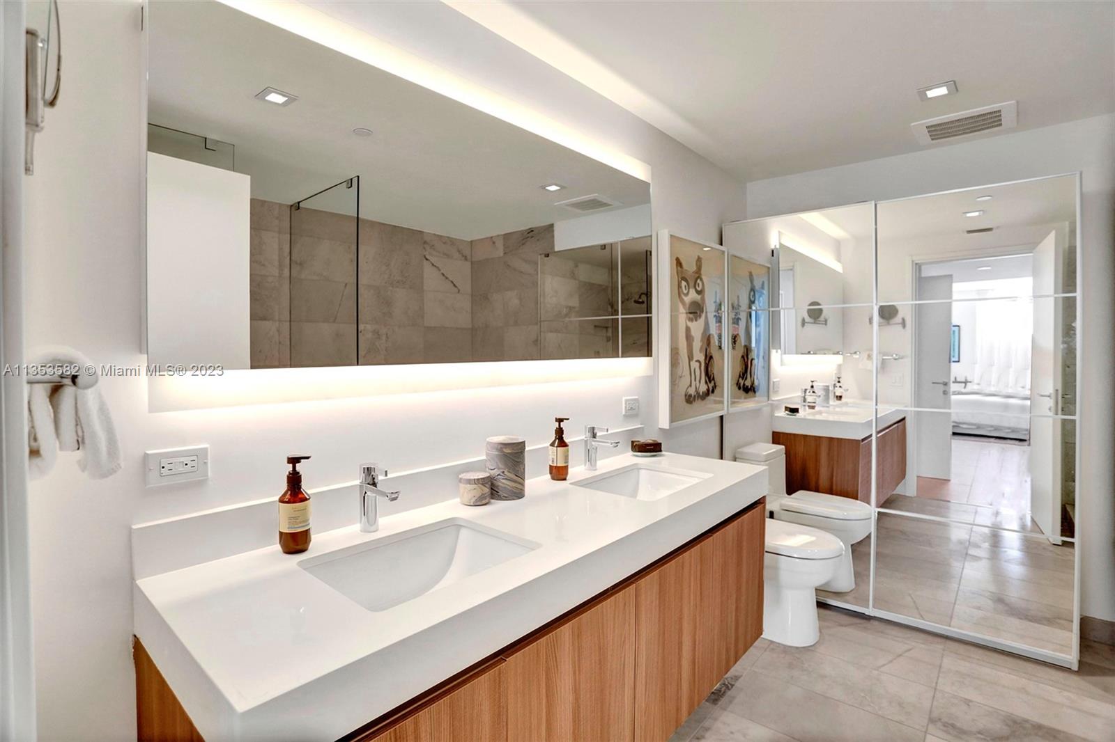 401 North Birch Road, Unit 903 Fort Lauderdale, FL 33304 - Photo 27 of 42 a bathroom with a double vanity sink mirror and toilet