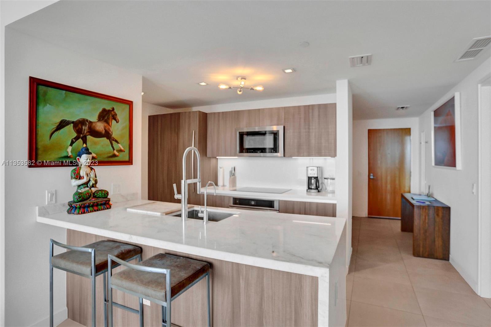 401 North Birch Road, Unit 903 Fort Lauderdale, FL 33304 - Photo 6 of 42 a kitchen with a sink and a refrigerator