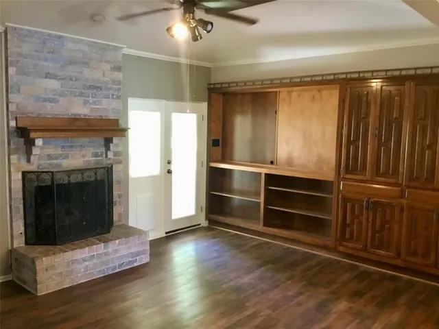 a living room with wooden floor and fireplace